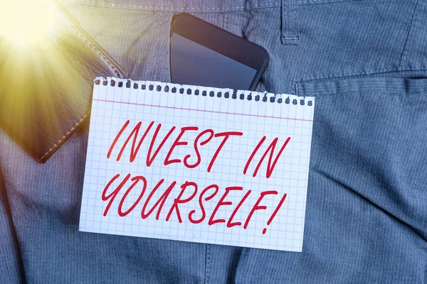 Tekst pisma "Inwestuj w siebie". Koncepcja nvesting w autokarze lub szkolenia, aby dowiedzieć się nowych rzeczy Smartphone urządzenie wewnątrz kieszeni spodni z portfela i papieru notatkowego. — Zdjęcie stockowe