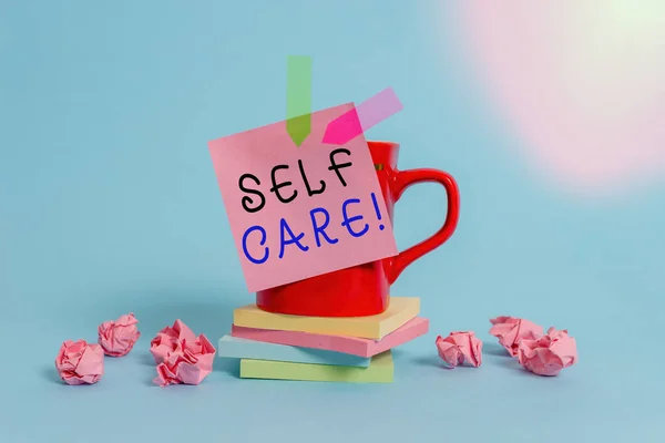 Conceptual hand writing showing Self Care. Business photo text practice of taking action preserve or improve ones own health Coffee cup sticky note banners paper balls pastel background. — Stock Photo, Image
