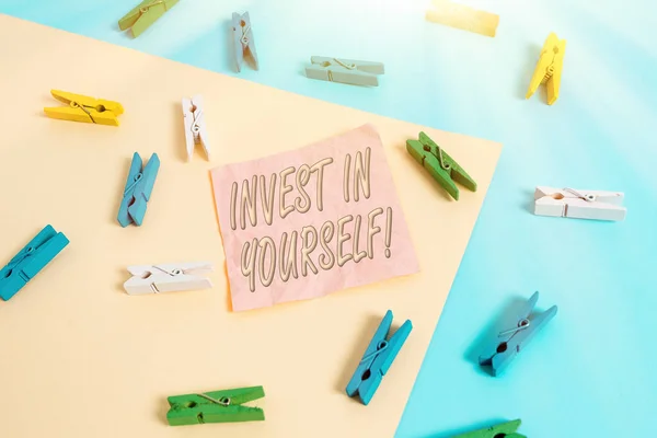 Text sign showing Invest In Yourself. Conceptual photo nvesting in a coach or a training to learn new things Colored clothespin paper empty reminder yellow blue floor background office. — Stock Photo, Image