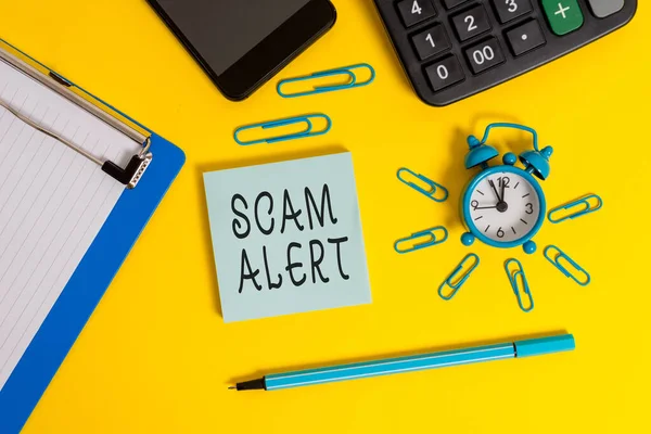 Scrivere testo Scam Alert. Concetto che significa email indesiderate che rivendica la prospettiva di un affare Appunti di allarme clip smartphone marcatore calcolatore blocco note colore sfondo . — Foto Stock