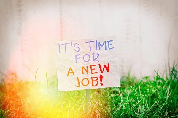 Conceptual hand writing showing It Time For A New Job. Business photo showcasing having paid position regular employment Plain paper attached to stick and placed in the grassy land. — Stock Photo, Image