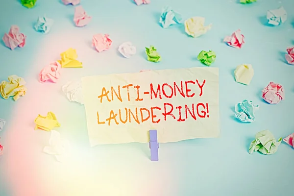 Word writing text Anti Money Laundering. Business concept for regulations stop generating income through illegal actions Colored crumpled papers empty reminder blue floor background clothespin.