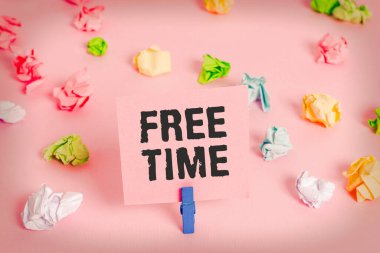 Boş Zamanı gösteren metin işareti. Hobiler ve hoşlandığınız diğer aktiviteler için kullanılabilir kavramsal fotoğraf zamanı Renkli buruşmuş kağıtlar boş hatırlatıcı pembe zemin çamaşır mandalı.