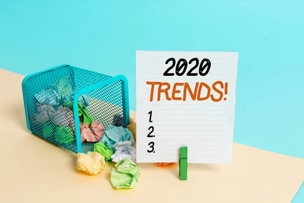 Conceptual hand writing showing 2020 Trends. Business photo showcasing general direction in which something is developing or changing Trash bin crumpled paper clothespin reminder office supplies.