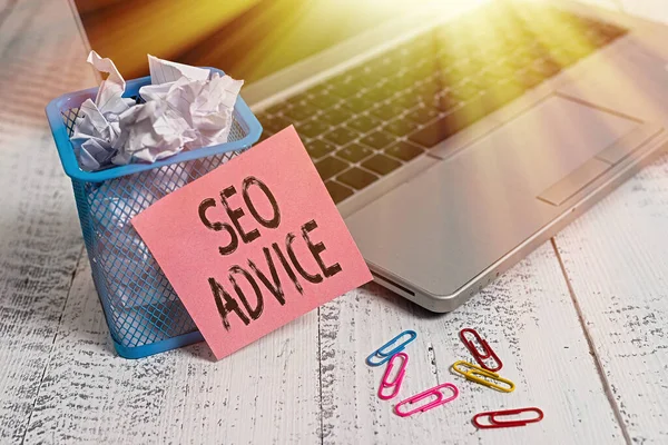 Conceptual hand writing showing Seo Advice. Business photo showcasing guidance or recommendations in enhancing the search engine Metallic laptop sticky note bin paper clips vintage table.