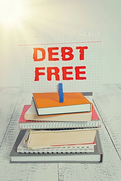 Writing note showing Debt Free. Business photo showcasing free from owning any money to any individual or a company pile stacked books notebook pin color reminder white wooden.