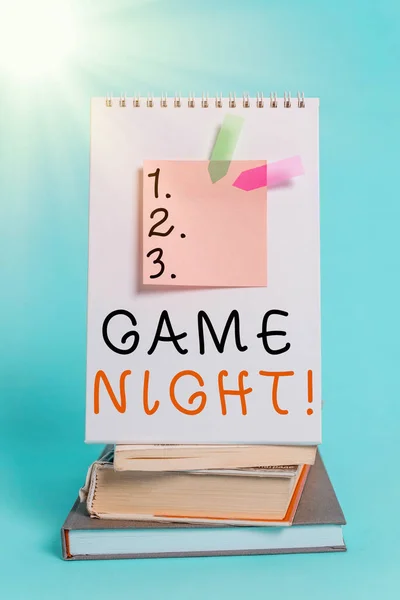 Conceptual hand writing showing Game Night. Business photo showcasing usually its called on adult play dates like poker with friends Spiral notebook sticky note banners books pastel background. — Stock Photo, Image