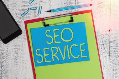 Seo Servisini gösteren bir not yazıyorum. Web sitesinin görünürlüğünü arttırmak için iş fotoğrafı gösterme teknikleri ve prosedürleri. Kağıt kalem notu akıllı telefon ahşap arkaplanı kırpıyor.