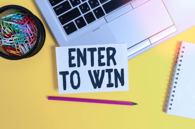 Enter To Win 'i gösteren not yazılıyor. İş fotoğrafı gösterimi ödüllü şans için bir şey değiş tokuşu ödüllü Laptop kare kalem kağıdı kağıt sayfa kaplama sarmal arka plan.