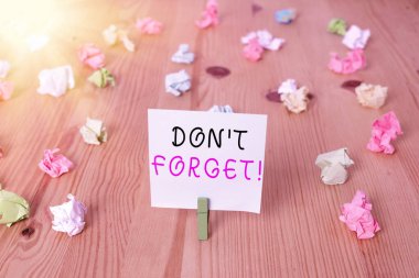 El yazısı metni, unutma. Kavram anlamı, birine önemli bir gerçeği veya detayı hatırlatmak için kullanılır. Renkli buruşmuş kağıtlar boş hatırlatıcı tahta zemin çamaşır mandalı.