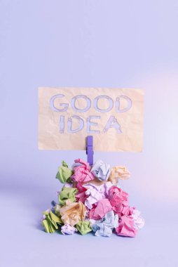 Handwriting text writing Good Idea. Concept meaning an excellent suggestion and plan for achieving something Reminder pile colored crumpled paper clothespin reminder blue background. clipart