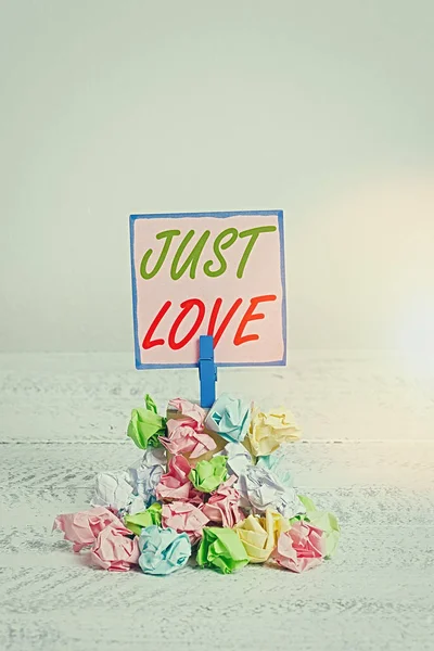 A Just Love felirat. Fogalmi fotó, hogy érdekli fizikailag valaki Egy érzelmi kötődés Emlékeztető halom színes összegyűrt papír ruhacsap emlékeztető fehér fa hely. — Stock Fotó