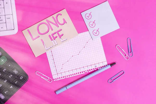 Text sign showing Long Life. Conceptual photo able to continue working for longer than others of the same kind Stationary and note paper plus math sheet with diagram picture on the table.