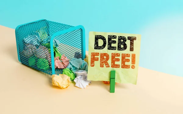Writing note showing Debt Free. Business photo showcasing does not owning any money or things to any individual or companies Trash bin crumpled paper clothespin reminder office supplies.