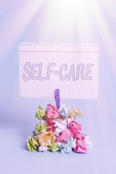 Writing note showing Self Care. Business photo showcasing the practice of taking action to improve one s is own health Reminder pile colored crumpled paper clothespin wooden space. — Stock Photo, Image