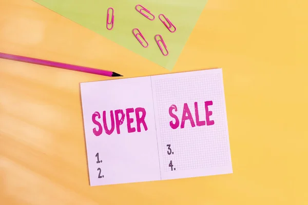 Text sign showing Super Sale. Conceptual photo offering exceptional discounts on selected products and services Blank paper sheet pencil clips smartphone two notepads colored background. — Stock Photo, Image