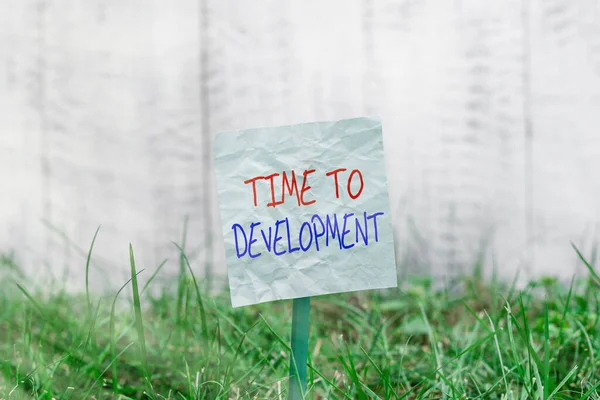 Handwriting text Time To Development. Concept meaning a length of time during which a company grows or develop Plain empty paper attached to a stick and placed in the green grassy land.