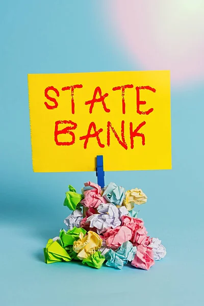 Slovo psaní textu State Bank. Obchodní koncepce pro obecně finanční instituci, která je najímána státem. Připomenutí hromada barevných zmačkaný papír prádlopin připomenutí modré pozadí. — Stock fotografie