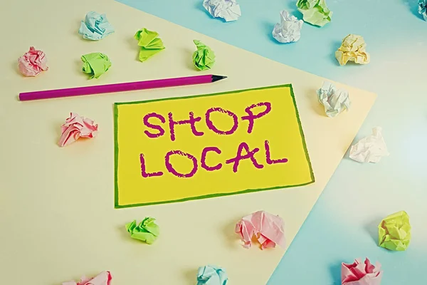 Writing note showing Shop Local. Business photo showcasing a preference to buy locally produced goods and services Colored crumpled papers empty reminder blue yellow clothespin.
