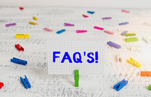 Sinal de texto mostrando Faq. Foto conceitual uma lista de perguntas e respostas relativas a um determinado assunto Green clothespin white wood background colored paper reminder office supply . — Fotografia de Stock