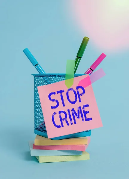 Text sign showing Stop Crime. Conceptual photo the effort or attempt to reduce and deter crime and criminals Sticky note arrow banners stacked pads metal pens holder pastel background. — Stock Photo, Image