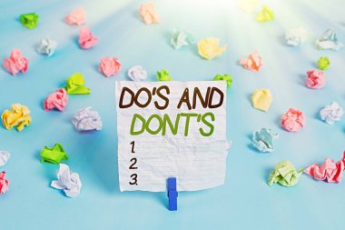 Yazı işareti, Do S ve Don 't S. kavramsal fotoğraf kuralları ya da bazı eylemlerle ilgili gelenekleri gösteriyor. Renkli buruşmuş kağıtlar, boş hatırlatıcı mavi zemin çamaşır mandalı..