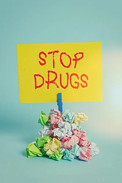 Λέξεις που γράφουν: Σταματήστε τα ναρκωτικά. Επιχειρηματική ιδέα για να τεθεί τέλος στην εξάρτηση από ουσίες όπως η ηρωίνη ή η κοκαΐνη Υπενθύμιση σωρός χρωματισμένο τσαλακωμένο χαρτί clothespin υπενθύμιση μπλε φόντο. — Φωτογραφία Αρχείου