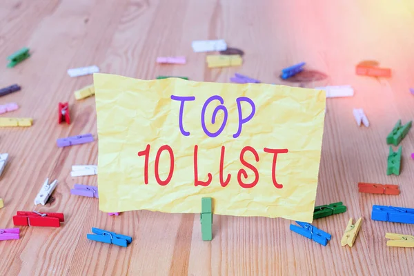 Writing note showing Top 10 List. Business photo showcasing the ten most important or successful items in a particular list Colored clothespin papers empty reminder wooden floor background office.