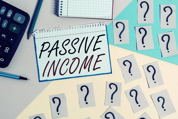 Writing note showing Passive Income. Business photo showcasing the earnings derived from a rental property and others Mathematics stuff and writing equipment above pastel colours background.