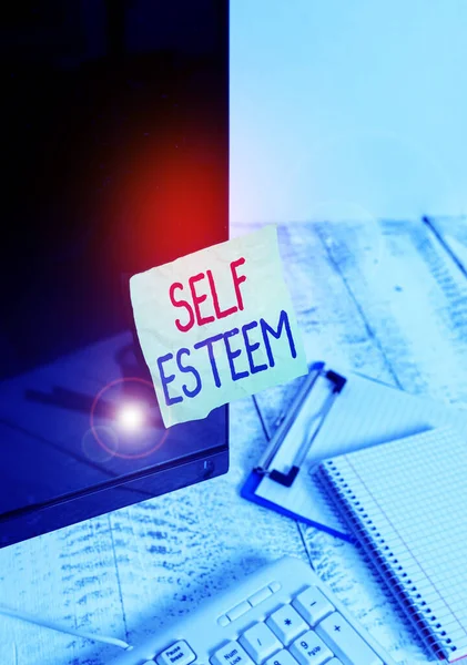 Writing note showing Self Esteem. Business photo showcasing a feeling of having respect for yourself and your abilities Note paper taped to black computer screen near keyboard and stationary.