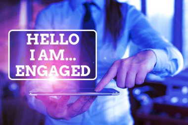 Handwriting text Hello I Am... Engaged. Concept meaning He gave the ring We are going to get married Wedding Blurred woman in the background pointing with finger in empty space. clipart
