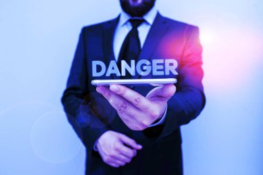 Tehlike 'yi yazan el yazısı. Kavram demek, hoş olmayan ya da tatsız bir şey olma olasılığı demektir. Erkek insan kıyafeti giyer. Akıllı, yüksek teknoloji akıllı telefon kullan..