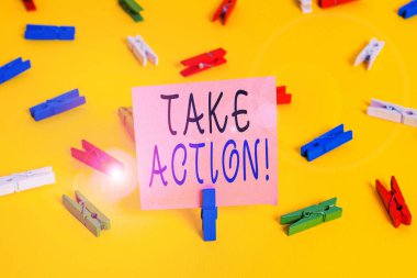 Harekete Geçildiğini gösteren metin işareti. Kavramsal fotoğraf resmi bir şey yap ya da sorunlu bir hedefe ulaşmak için uyumlu bir şey yap Renkli çamaşır iğnesi kağıtları boş hatırlatıcı sarı zemin arka plan ofisi.