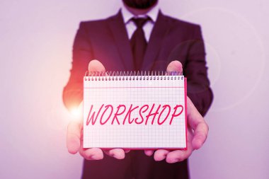 Word writing text Workshop. Business concept for room or building in which goods are analysisufactured or repaired Male human wear formal work suit office look hold mathematics book use hand.