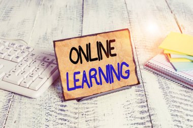 Çevrimiçi Öğrenme 'yi gösteren metin işareti. Bilgisayar klavyesi ve matematik sayfaları arasındaki tampon tel üzerinde Internet Notepaper standından tabanlı ve erişilebilir kavramsal fotoğraf eğitim aracı.