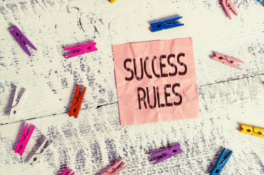 Handwriting text Success Rules. Concept meaning able to achieve all the goals that you have set for yourself Colored clothespin rectangle square shaped paper white wood background.