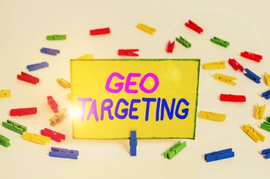 Writing note showing Geo Targeting. Business photo showcasing method of determining the geolocation of a website visitor Colored clothespin papers empty reminder white floor background office.