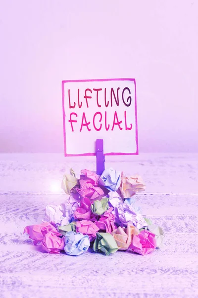 Word writing text Lifting Facial. Business concept for plastic surgery on the face and neck to remove defects Reminder pile colored crumpled paper clothespin reminder white wooden space.
