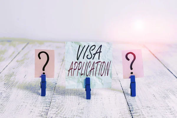 Writing note showing Visa Application. Business photo showcasing an process of getting an entry permit to a foreign land Crumbling sheet with paper clips placed on the wooden table.