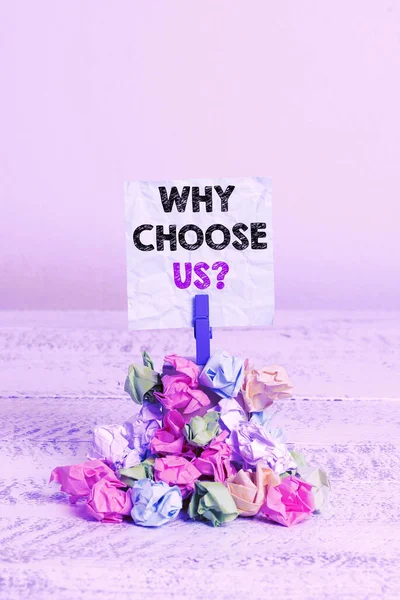 Handwriting text Why Choose Us question. Concept meaning Reasons for choosing our brand over others arguments Reminder pile colored crumpled paper clothespin reminder white wooden space.