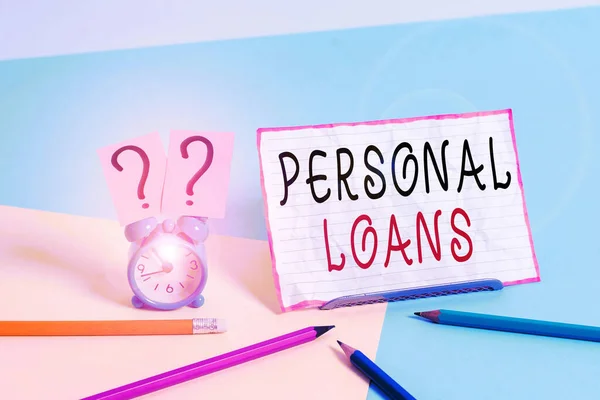 Text sign showing Personal Loans. Conceptual photo unsecured loan and helps you meet your financial needs Mini size alarm clock beside stationary placed tilted on pastel backdrop.