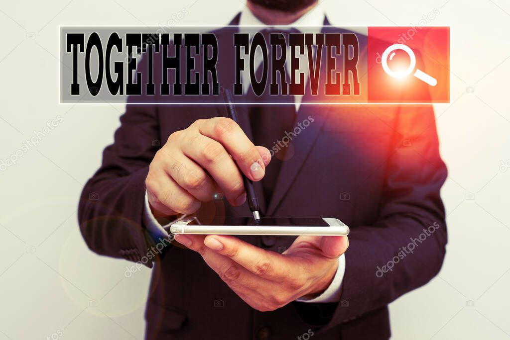 Handwriting text writing Together Forever. Concept meaning showing who promise to love one another for eternity Male human wear formal work suit hold smart hi tech smartphone use one hand.