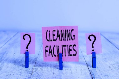 Temizlik Tesisleri 'ni gösteren mesaj işareti. Kavramsal fotoğraf yeri ya da temizlik amacıyla sağlanan ekipman ahşap masaya raptiye ile karalanmış ve parçalanmış çarşaf.