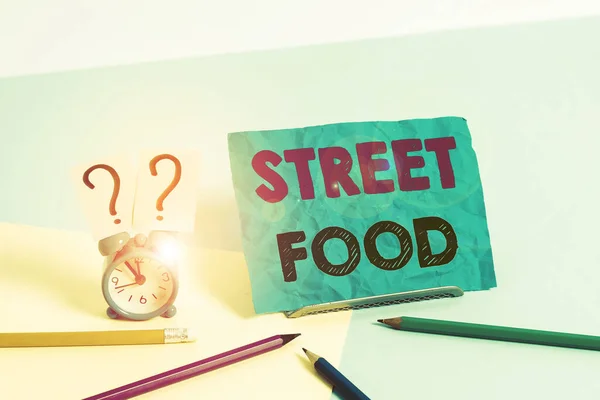 Word writing text Street Food. Business concept for cooked food sold by vendors in a street or other public location Mini size alarm clock beside stationary placed tilted on pastel backdrop. — Stockfoto