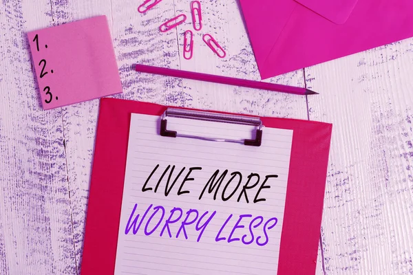Writing note showing Live More Worry Less. Business photo showcasing Have a good attitude motivation be careless enjoy life Clipboard paper sheet pencil envelope clips notepad wooden background. — Stock Photo, Image