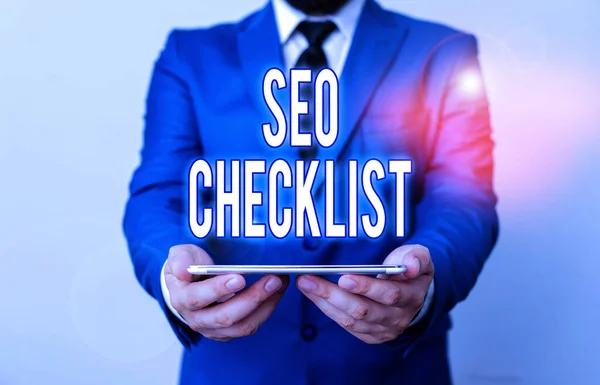 Texto de escritura de palabras Seo Checklist. Concepto de negocio para la lista de artículos necesarios para optimizar el motor de búsqueda Empresario en suite azul con una corbata sostiene la parte superior de la falda en las manos . —  Fotos de Stock