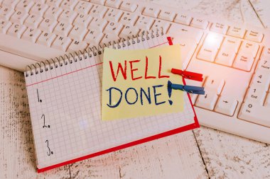 Bravo 'yu gösteren bir not yazıyorum. İş fotoğraflarının sergilenmesi, gösteri grubunu övmek için iyi bir yol bulmuş. Defter hatırlatma çengeli, çivilenmiş tahta çarşaf..