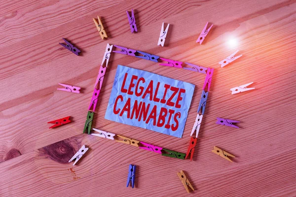 合法化された大麻を示す概念的な手書き。合法化されたレクリエーション大麻が全国的に使用するビジネス写真テキスト法色砕いた紙木製の床の背景の服ピン. — ストック写真