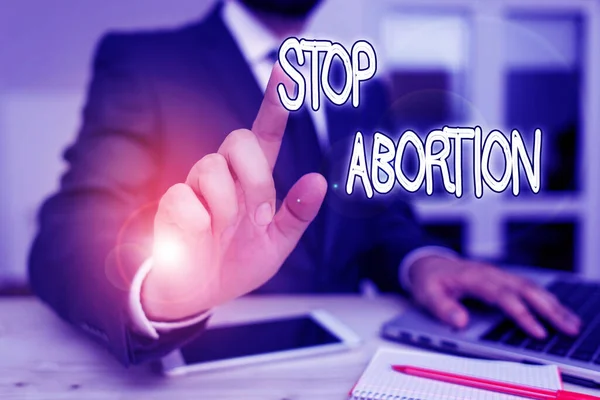 Manuscrito texto Stop Abortion. Conceito significado para parar o procedimento médico que costumava acabar com uma gravidez Masculino desgaste humano roupas formais presente apresentação use oi tech smartphone . — Fotografia de Stock