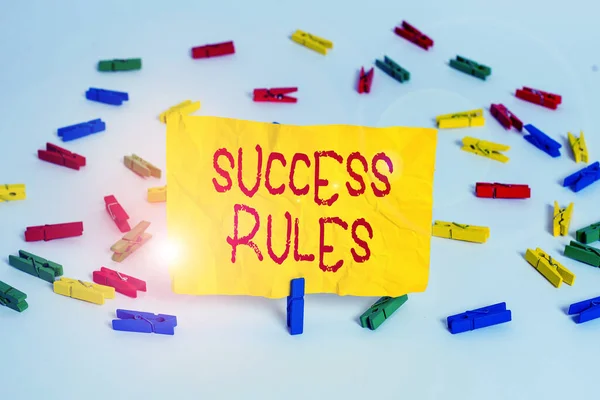 Word writing text Success Rules. Business concept for able to achieve all the goals that you have set for yourself Colored clothespin papers empty reminder white floor background office.